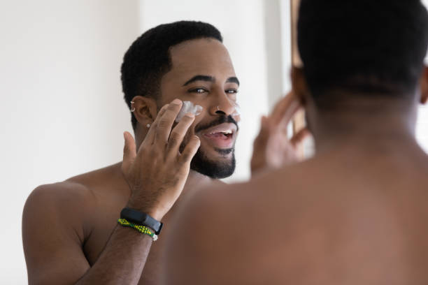 istock Close up positive African American young man applying face cream 1265210676