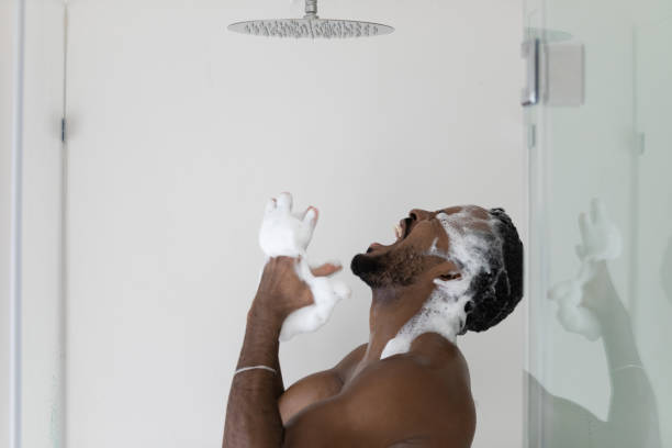 怒っている石鹸アフリカ系アメリカ人男性は、壊れたシャワーに不満 - men naked shower bathroom ストックフォトと画像