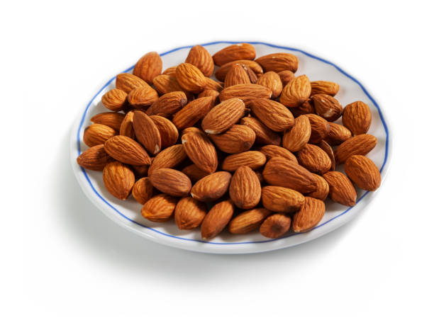 istock peeled almonds on a white saucer with a blue border, isolated on a white background 1265212474