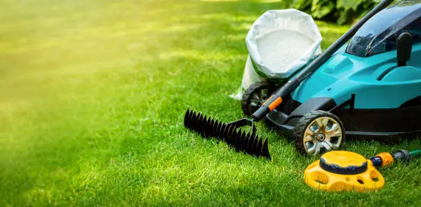 Photo of garden lawn care tools and equipment for perfect green grass. banner copy space