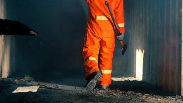 istock Firefighter fighting with flame using fire hose chemical water foam spray engine. Fireman wear hard hat, body safe suit uniform for protection. Rescue training in fire fighting extinguisher 1265213827