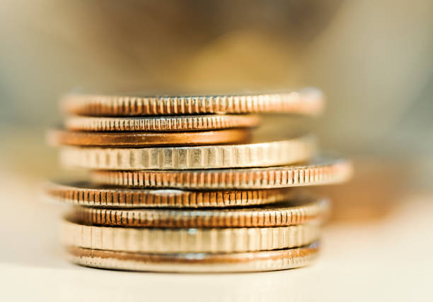 Heaps of money or pile of gold colored golden currency coins arranged as mountain or set or stacks of abundant wealth placed on a wooden surface over glittering shiny horizontal background or starry Dhanteras festival celebration backdrop.