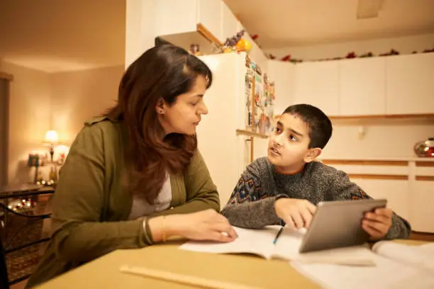 Shot of a woman helping her young son with his homework