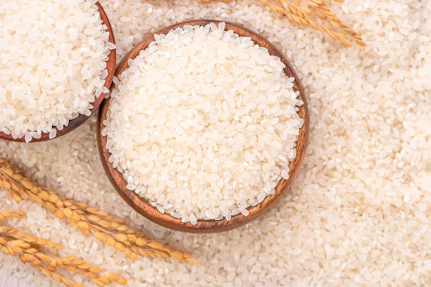 istock Raw rice in a bowl and full frame in the white background table, top view overhead shot, close up 1265223357