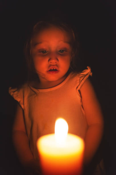 Sweet girl with a candle during a power outage.