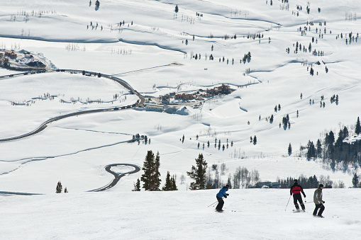 Wyoming, USA - February 3, 2011: Trio of adult snowboarders begin their journey down the mountain at Jackson Hole.