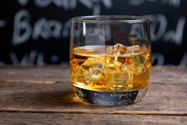 istock Glass with whiskey and ice on bar counter 1265228015