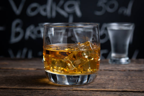 istock Glass with whiskey and ice on bar counter 1265228062