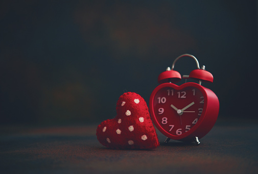Red heart shaped alarm clock with heart. Time for love. Valentine's Day conceptual image