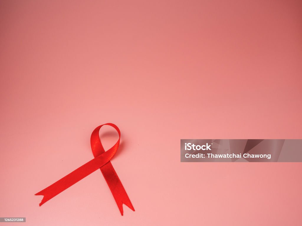 Red ribbon on pink background. world aids day concept, symbol of human immunodeficiency virus disease. World AIDS Day Stock Photo