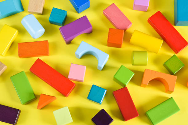 istock Wooden colorful cubes on a yellow background. Construction. 1265232966
