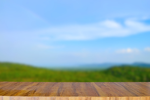 Empty wooden table top for place products and anything on blurred nature landscape background