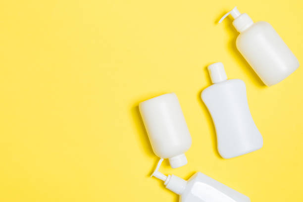 istock Set of White Cosmetic containers isolated on yellow background, top view with copy space. Group of plastic bodycare bottle containers with empty space for you design 1265233512