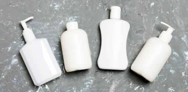 istock Set of White Cosmetic containers isolated on yellow background, top view with copy space. Group of plastic bodycare bottle containers with empty space for you design 1265233518