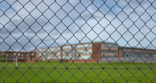 High School Building Behind A Fence