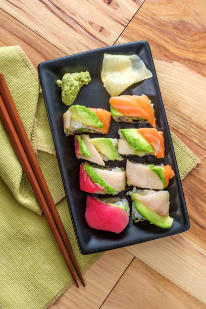 Rainbow Sushi Roll Fresh rainbow sushi roll sliced with wasabi and fresh ginger rainbow crab stock pictures, royalty-free photos & images