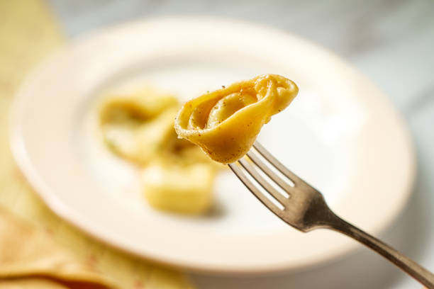 Tortellini with butter and parmesan cheese on marble kitchen table