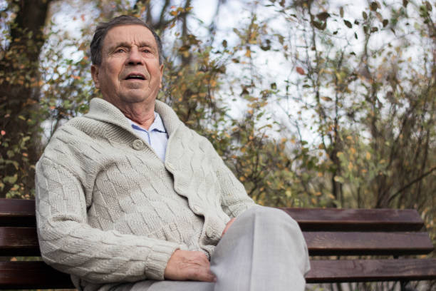 istock Senior man sitting on bench in the park 1265239482