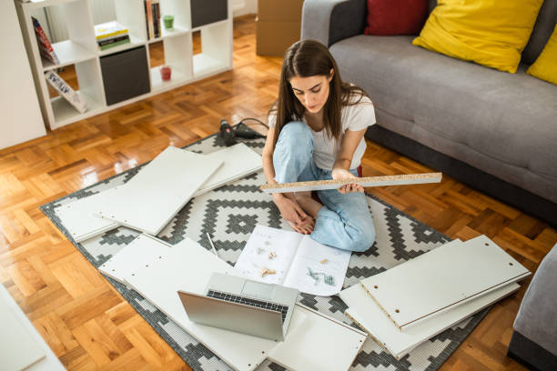 istock Woman is assembling furniture at home 1265241079