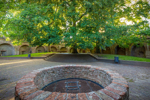 Fountain with stone wall of church at the old town of Swiss City of Winterthur on a cloudy spring day. Photo taken May 17th, 2023, Winterthur, Switzerland.