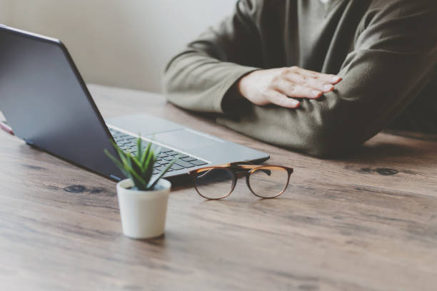 istock Man typing on a laptop keyboard on a wooden table and tree. 1265241128