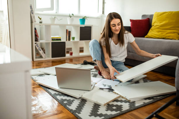 istock Woman is assembling furniture at home 1265241273