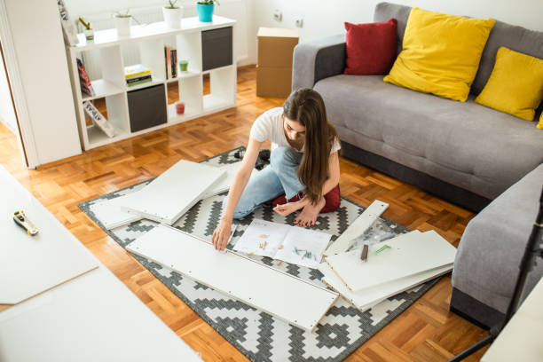 istock Woman is assembling furniture at home 1265241334