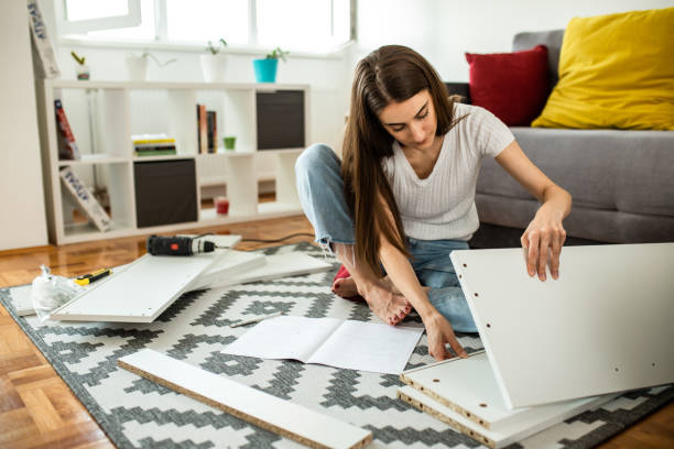 istock Woman assembling flat pack furniture at home 1265241699