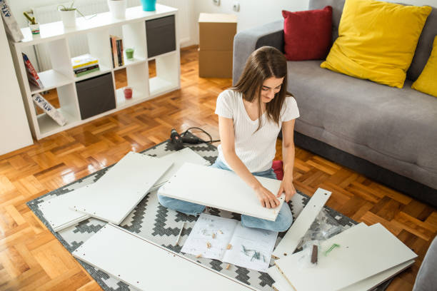 istock Woman assembling flat pack furniture at home 1265242447