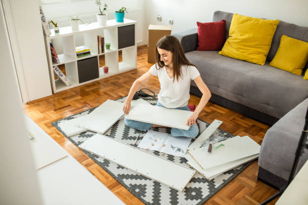 istock Woman assembling flat pack furniture at home 1265242495