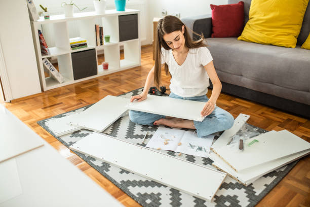 istock Woman assembling flat pack furniture at home 1265242613