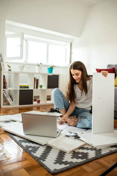 istock Woman assembling flat pack furniture at home 1265243608