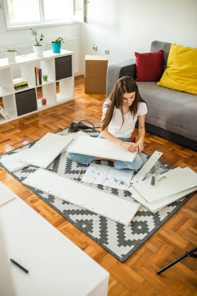 istock Woman is assembling furniture at home 1265244194