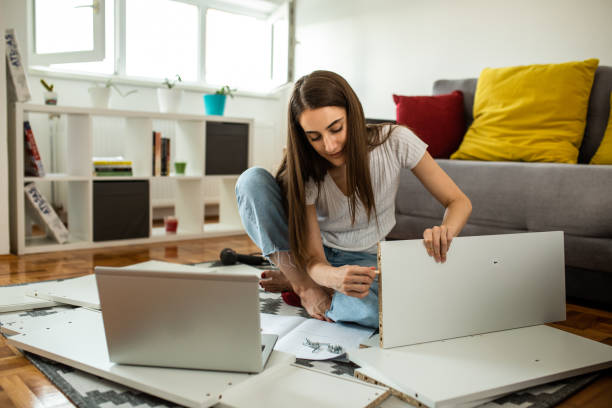 istock Woman is assembling furniture at home 1265245072