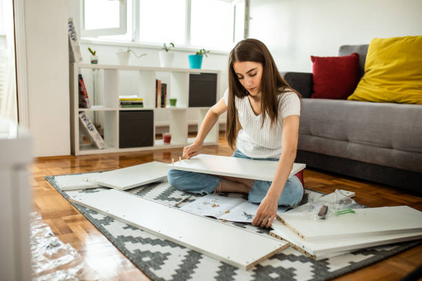 istock Woman assembling flat pack furniture at home 1265245181