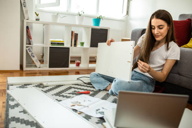 istock Woman assembling flat pack furniture at home 1265245600