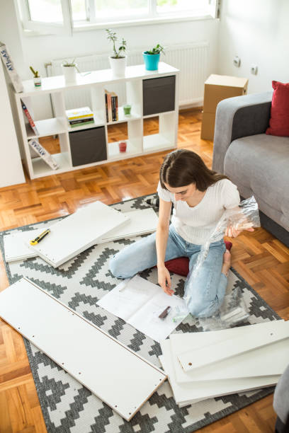 istock Woman assembling flat pack furniture at home 1265246434