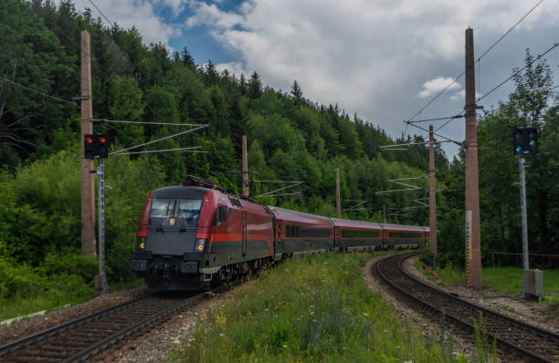 Violet Austria train in Klamm station near Semmering pass in summer cloudy day stock photo