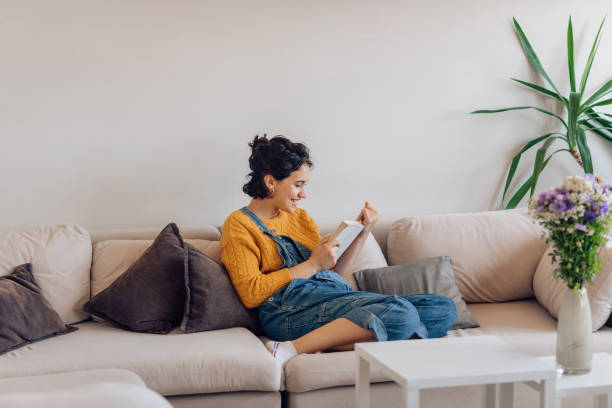 istock Girl relaxing on the sofa and reading a novel 1265249085