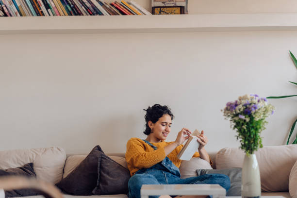 istock Girl enjoying on the sofa and reading a book 1265249133