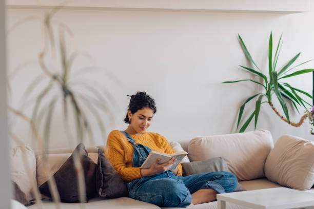 istock Girl enjoying at her apartment, reading a book 1265249142
