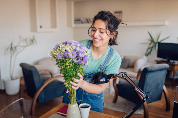istock Girl enjoying arranging flowers at home 1265249151