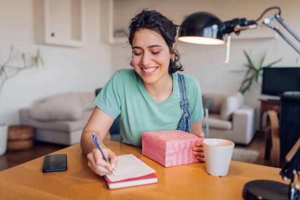 istock Girl preparing a care package for someone special 1265249273