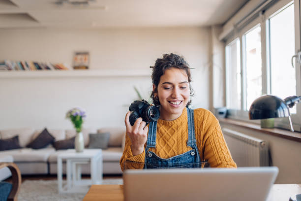 jovem fotógrafa trabalhando em suas fotos em seu escritório em casa - fotógrafo - fotografias e filmes do acervo