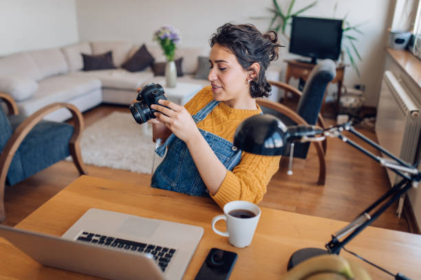 istock Young woman adjusting her camera at home office 1265249321