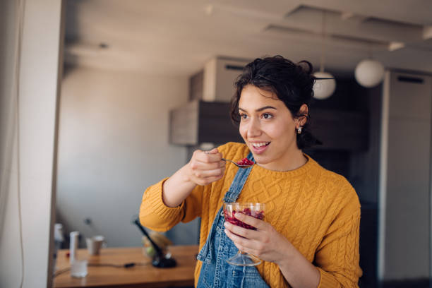 istock Young woman enjoying at home and eating pomegranate 1265249352
