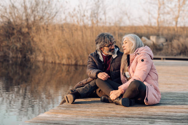 istock Senior couple talking and enjoying together on the river dock 1265253331