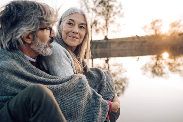 istock Happy seniors enjoying by the river with sunset 1265253332