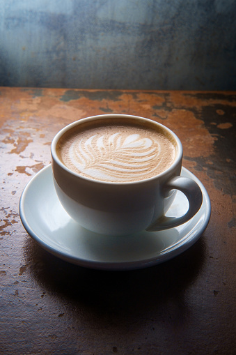 Hot morning Italian latte with cream in rustic atmosphere