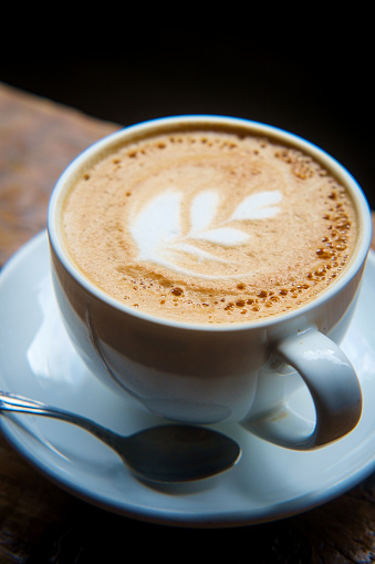 Hot morning Italian latte with cream in rustic atmosphere